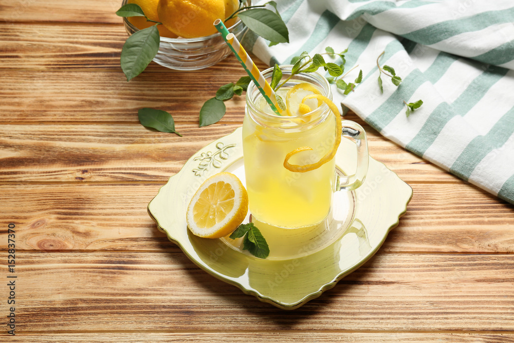 Delicious lemon juice in mason jar on wooden background