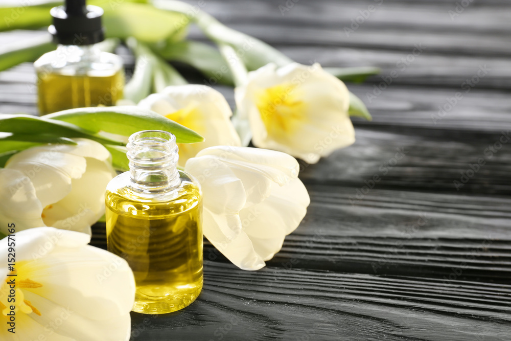 Composition with perfume and flowers on wooden table
