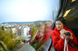 One Asian adult female visitor holding camera and looking at view through SBB train window in Zurich, Switzerland