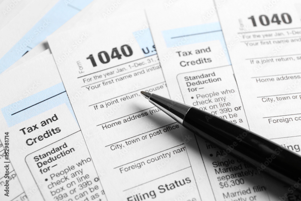 Individual Tax Return Forms and pen on table