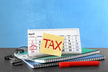 Poster - Paper sheet with word TAX, calendar and notebooks on table