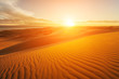 Picturesque desert landscape with a golden sunset over the dunes