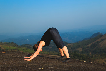 Wall Mural - Young woman is exercising in the mountains.