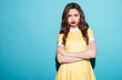 © Drobot Dean - Cute upset girl in dress standing with arms folded