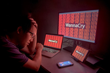 Wall Mural - WannaCry ransomware attack on desktop screen, notebook and smartphone, internet cyber attack with Anonymous calling on smart phone to get the ransoms payment to decrypt the code
