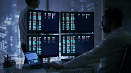 Aufkleber - Late at Night in Trader's Bureau. Stockbroker Reads Numbers on His Multiple Displays with Stock Information on Them, He Also Consults Clients with Headset On. Shot on RED EPIC-W 8K Helium Camera