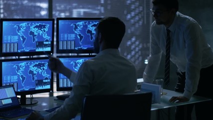 Leinwandbilder - Late at Night in Office Building Security Service Men Have Discussion while  Attentively Observing Monitors with Location Sensitive Information Shown on Them. Shot on RED EPIC-W 8K Helium Camera