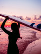 © artifirsov - Surf girl with long hair go to surfing. Silhouette of a woman with surfboard on a beach at sunset or sunrise. Surfer and ocean