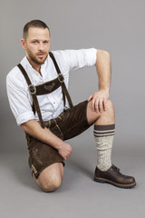 Wall Mural - man in bavarian traditional lederhosen kneeling