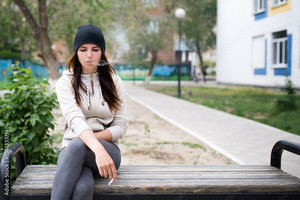 Young girl smoking cigarette outdoors. Stock Photo