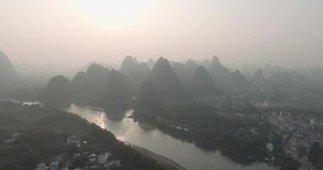 Sticker - Aerial shot of passenger boats,rafts in beautiful Li River surrounded by karst mountains at sunset or sunrise in Yangshuo,Guilin,China. Travel, picturesque famous destination and adventure concept.