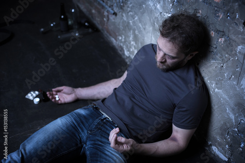 Fotografia Heavy drug user suffering from overdose in the darkness