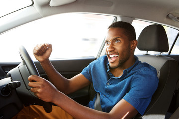 Wall Mural - Excited young african american man driving a car