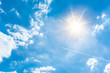 Leinwandbild Motiv Sunny background, blue sky with white clouds and sun