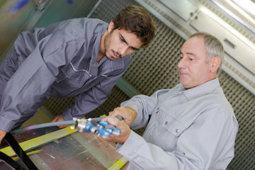 Wall Mural - metal worker teaching trainee on machine use