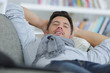 © auremar - man laying on sofa relaxing