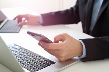Poster - Hands of businessman using mobile phone in modern office with laptop and digital tablet computer with VR icon diagram