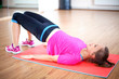 Happy woman doing pelvic muscle exercise on mat