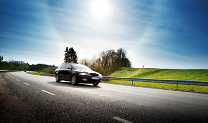 Car on asphalt road in beautiful spring day at countryside