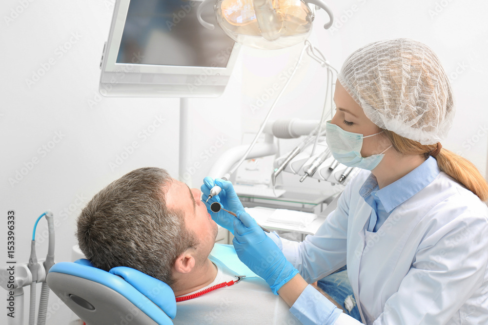 Dentist examining patient's teeth in clinic