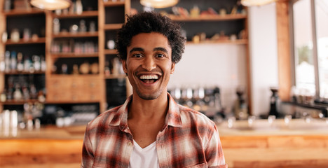 Poster - Happy young man laughing in a cafe