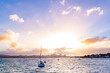 sunset above Auckland city’s skyline with the harbour, the ocean and some boats at the front