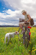 Frau mit Hund und Fahrrad unterwegs