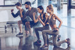 © LIGHTFIELD STUDIOS - group of athletic young people in sportswear doing lunge exercise at the gym, aerobic fitness concept