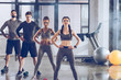© LIGHTFIELD STUDIOS - Group of athletic young people in sportswear exercising at the gym