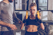 © LIGHTFIELD STUDIOS - sportive woman exercising with trx gym equipment with trainer near by