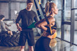 © LIGHTFIELD STUDIOS - side view of sportive woman exercising with trx gym equipment with trainer near by