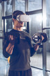 © LIGHTFIELD STUDIOS - side view of man in virtual reality headset exercising with dumbbells in gym