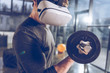 © LIGHTFIELD STUDIOS - side view of man in virtual reality headset exercising with dumbbell in gym