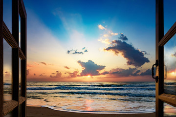 View of the sunrise over the sea from the open window