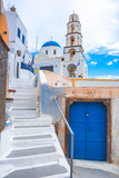 Fototapeta Uliczki - Old colorful wooden doors and bell tower at the traditional village of Pirgos, Santorini, Greece.