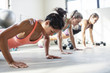 Female athletes doing push-ups in gym
