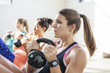 © Cavan Images - Female athletes lifting kettlebells in gym
