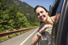 Portrait Of Happy Woman Looking Through Window While Traveling In Car
