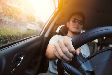 Asian man male ware sun glass drive a car.