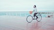 © kohanova1991 - Woman in sport clothing riding white vintage bicycle on seaside during cloudy rainy day
