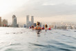 © SokRom - Mother and her children enjoying the view from roof top swimming pool in Singapore