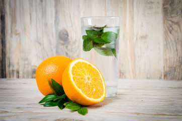 Wall Mural - Fresh lemonade drink with ice. Fruit. Orange and green mint leaves