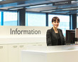 © Connect Images - Receptionist smiling at information desk