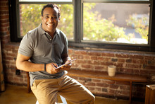 Man Posing With Charismatic Smile Holding Digital Tablet