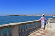 © Rageziv - Young woman in a hat standing on the bridge and looking on the city of Venice
