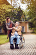 caregiver daughter with senior man in wheelchair.