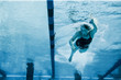 © Erickson Stock - Mid adult woman swimming laps in her local pool.