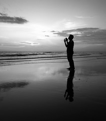 Silhouette Of Pray Guy with beautiful reflection on the beach.