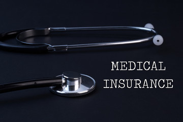 Wall Mural - Medical Insurance and Stethoscope on black background.