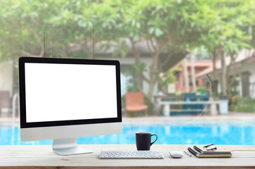 Poster - desktop computer on work table and see through resort hotel background